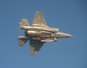F-35 showing off weapons bay under a deep blue sky