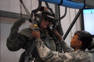 Darcie McCracken hangs from a mock-up parachute while receiving F-16 Life Support Egress Training from the 56th Operational Support Squadron before taking an orientation flight as an Honorary Commander.