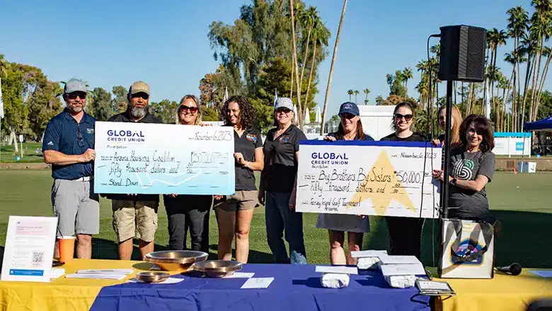 Global Credit Union holding charity checks at Fairway Friends in Phoenix, 2024.